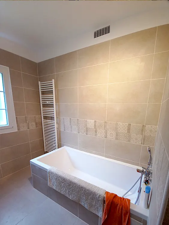 Conserver le confort d'une baignoire tout en modernisant l'ensemble de la pièce reste une demande fréquente. Cette réalisation met en avant un aménagement fonctionnel, des revêtements actuels et un espace adapté à la vie de famille. Projet réalisable sur Bandol, Sanary-sur-Mer, Saint-Cyr-sur-Mer et l'agglomération toulonnaise. Salle de bain familiale rénovée avec baignoire, sèche-serviettes et faïence décorative réalisée par Grech Salle de Bain à Sanary-sur-Mer