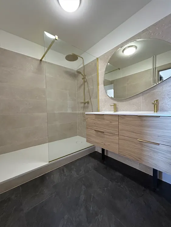 Douche généreuse, mobilier fonctionnel et matériaux faciles à entretenir : une rénovation conçue pour durer et simplifier le quotidien. Projet réalisé sur le secteur de Sanary-sur-Mer et de l'agglomération toulonnaise. Rénovation de salle de bain avec double vasque, douche contemporaine et paroi en verre