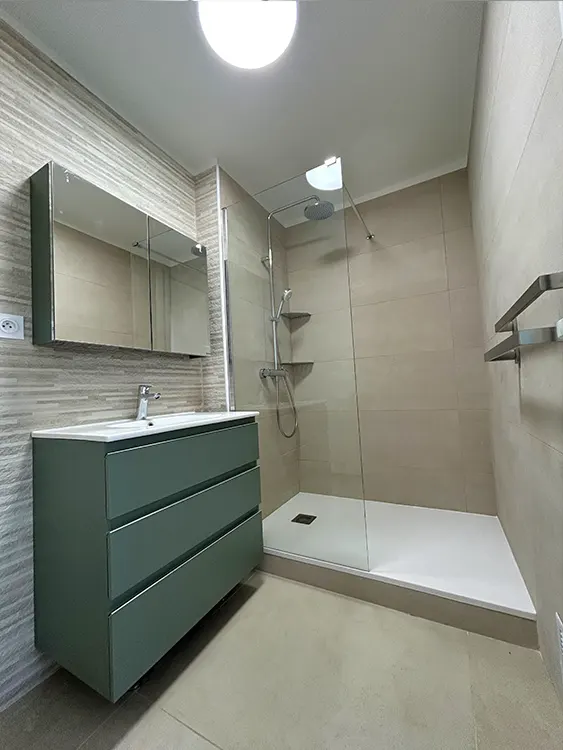 Chaque centimètre compte. Cette rénovation combine rangements, luminosité et douche confortable pour optimiser l'espace disponible au quotidien. Projet réalisé par Grech Salle de Bain sur le secteur de Sanary-sur-Mer et de l'agglomération toulonnaise. Rénovation de petite salle de bain avec meuble suspendu vert et douche extra-plate